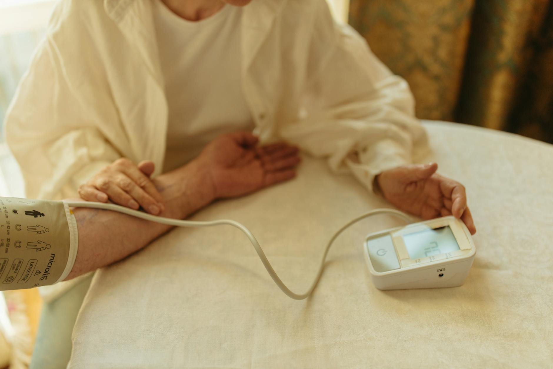 person using a digital blood pressure monitor
